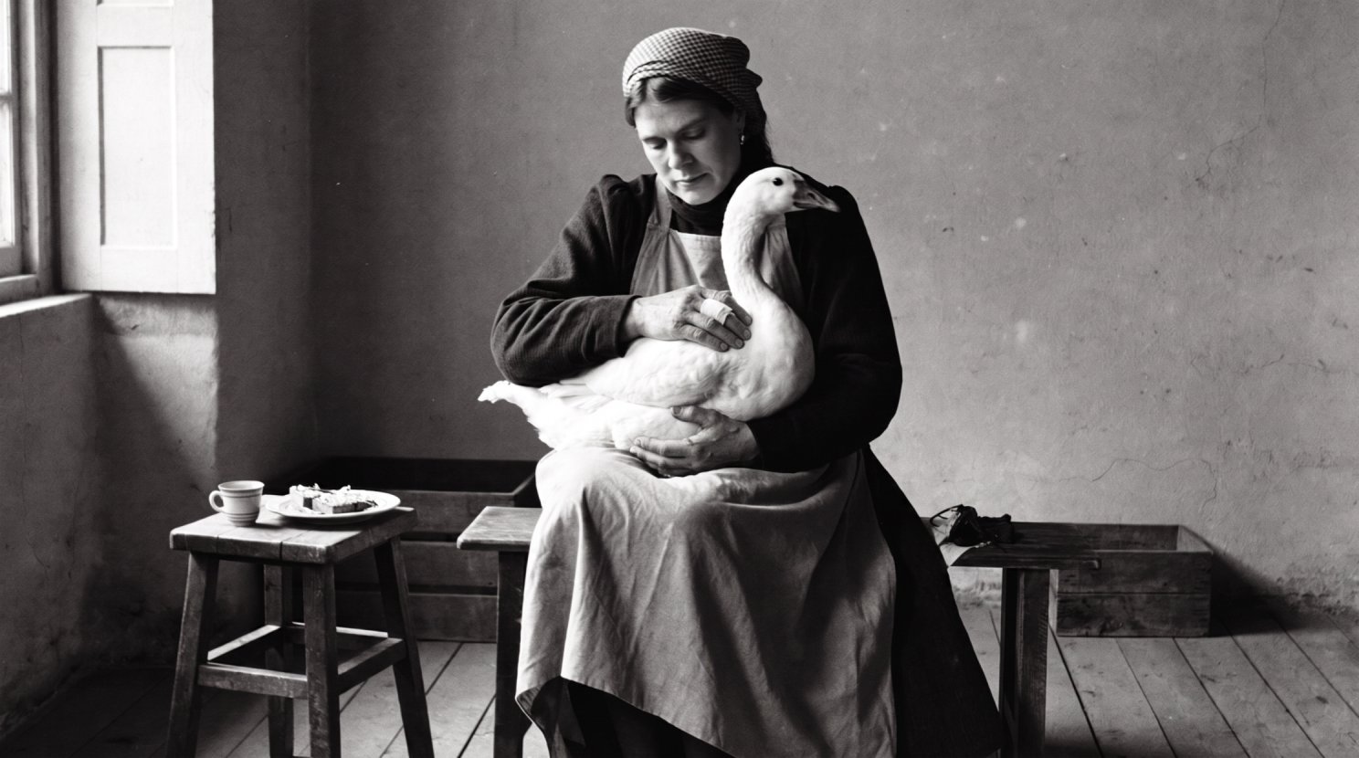 The mother holding the goose in her lap